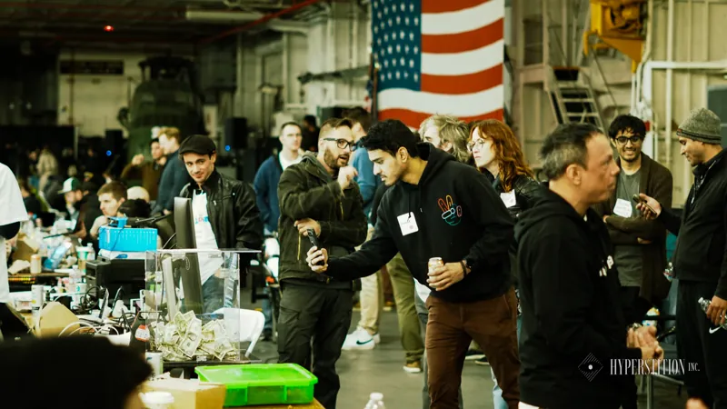 Participants gather around demonstrations inside the hangar.