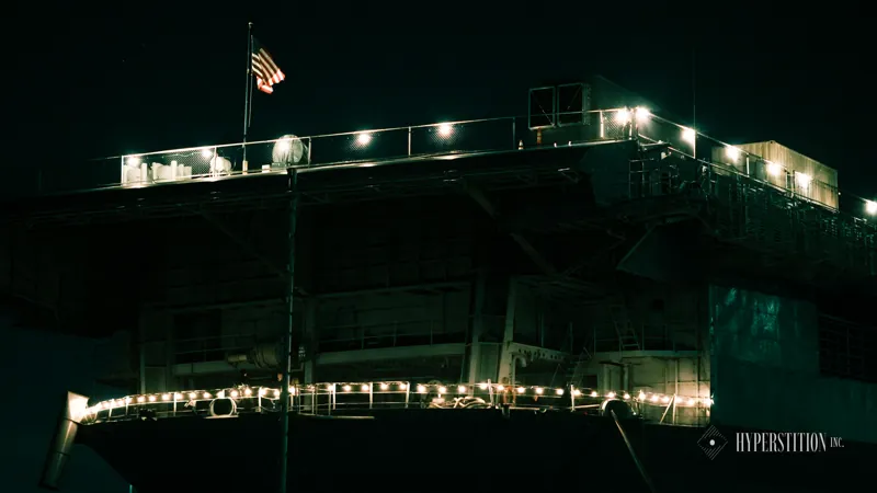 USS Hornet illuminated after dark.